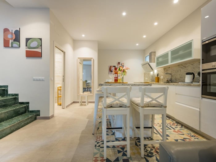 Open plan kitchen with island equipped with bar stools for five