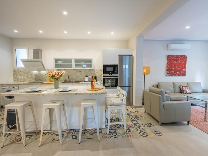 Open-plan kitchen with modern appliances and island with bar stools