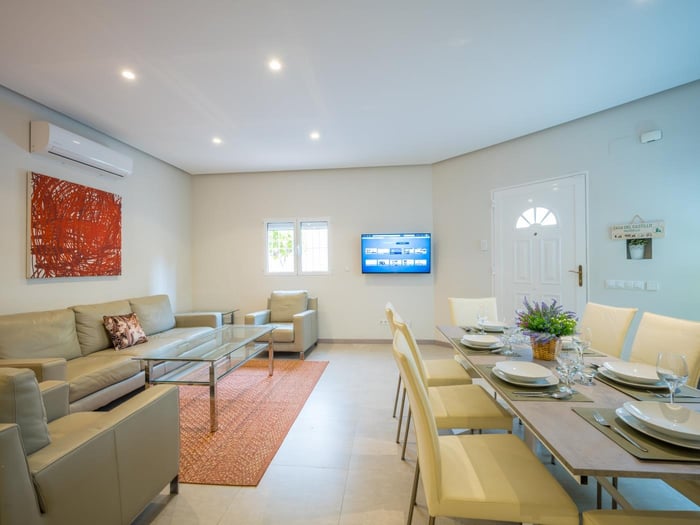 Sitting area with glass table surrounded with leather sofas in front of the flat screen